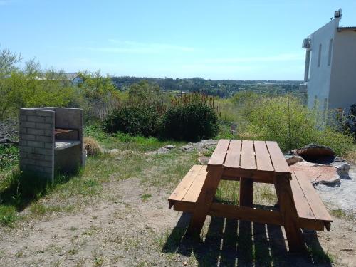 a wooden picnic table sitting on top of a field at La Cumbre in Sierra de los Padres