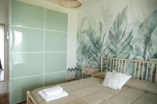 a bedroom with a bed with a tropical wallpaper at La Campagna di Peppe e Tullia in Formia