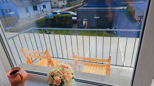 a balcony with two chairs and a bouquet of flowers at Beautiful 3 Room big Apartment with kitchen and Balcony in Kerpen
