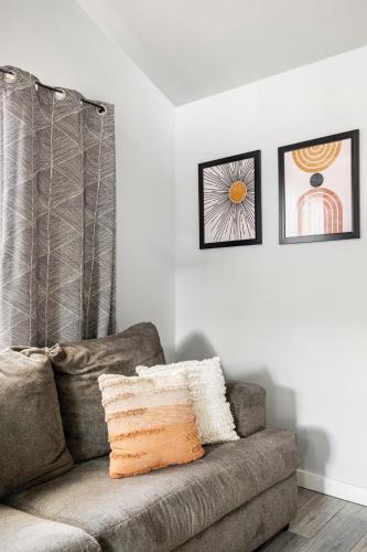 a couch in a living room with two pictures on the wall at Modern guest house in East Atlanta Village in Atlanta