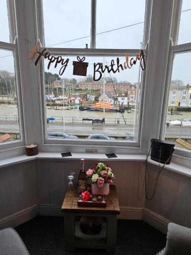 a window with a happy birthday sign in a room at The Ocean Guest House in Weymouth