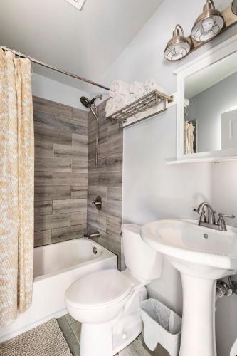 a bathroom with a white toilet and a sink and a tub at Modern guest house in East Atlanta Village in Atlanta