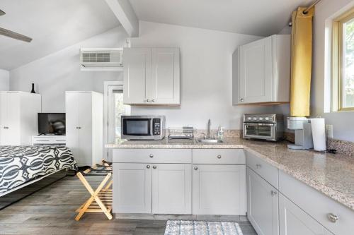 a white kitchen with white cabinets and a bed at Modern guest house in East Atlanta Village in Atlanta