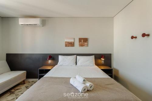 a bedroom with a bed with two towels on it at TCO - Apartamentos no Centro Histórico Porto Alegre/RS in Porto Alegre