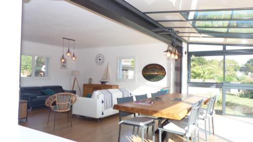 une salle à manger et un salon avec une table et des chaises dans l'établissement Confortable maison avec piscine a Larmor Baden, à Larmor-Baden