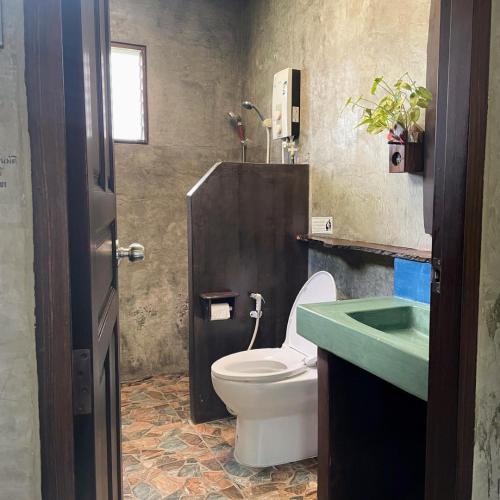 a bathroom with a toilet and a green sink at บ้านณัฐวรรณ หัวหิน - Baan Nattawan Huahin in Hua Hin