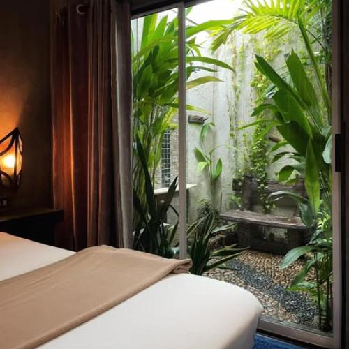 a bedroom with a bed and a window with plants at บ้านณัฐวรรณ หัวหิน - Baan Nattawan Huahin in Hua Hin