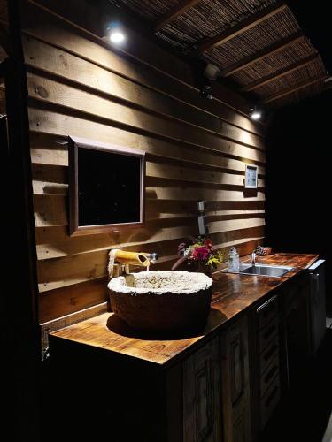 a bathroom with a large stone sink and a television at Goodmuda Tipi's in Grândola