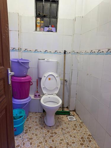 a bathroom with a toilet and two buckets at Toly’s Spacious One Bedroom in Nairobi
