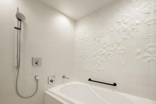 a white bathroom with a shower and a sink at Aloft Osaka Dojima in Osaka