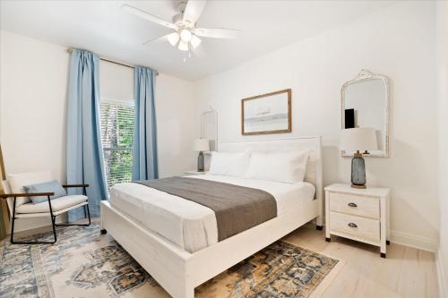 a white bedroom with a bed and a window at Brand New Luxury Rental on Oleander Unit E in Dauphin Island