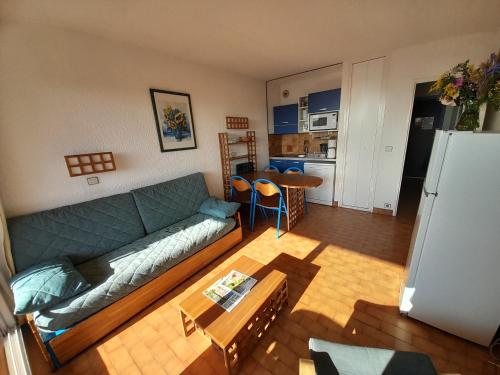 un salon avec un canapé vert et une cuisine dans l'établissement appartement côte d'azur vue mer, à Roquebrune-Cap-Martin