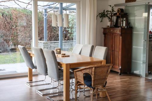 ein Esszimmer mit einem Holztisch und Stühlen in der Unterkunft Haus am See - Urlaub im Herzen des Münsterlands in Steinfurt