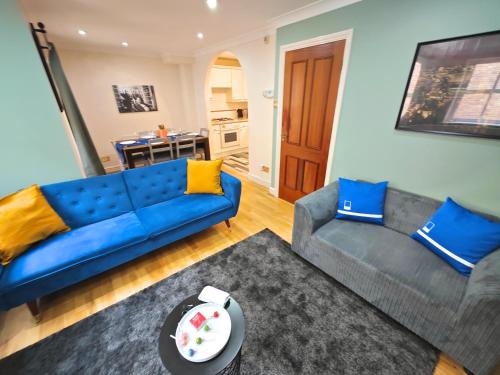 a living room with a blue couch and a table at Charming 3 Bed Home in Central London, Abbey Road in London