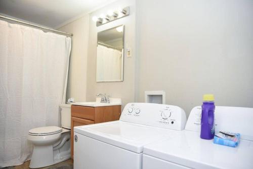 a white bathroom with a sink and a toilet at Bungalow near Main Street - #2 in Grand Bay
