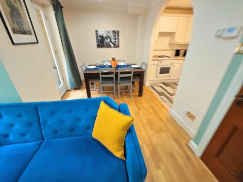 a blue couch with a yellow pillow in a living room at Charming 3 Bed Home in Central London, Abbey Road in London