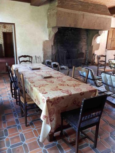 a dining room with a table and a fireplace at Grande maison aux portes de Vire in Burcy