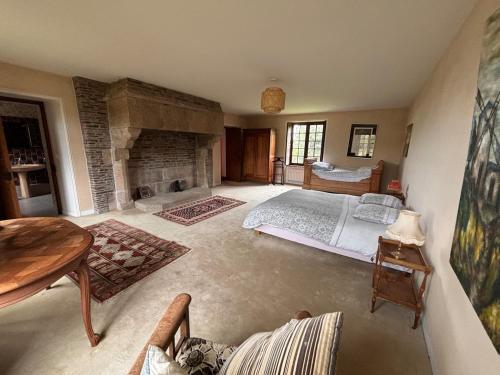 a large bedroom with a bed and a fireplace at Grande maison aux portes de Vire in Burcy