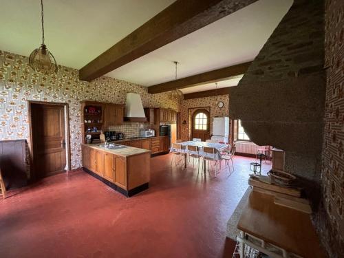 a kitchen and living room with a table and chairs at Grande maison aux portes de Vire in Burcy