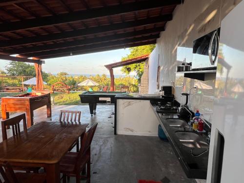 a kitchen with a table and a sink and a table and chairs at Pipa Golfinhos Pousada in Pipa