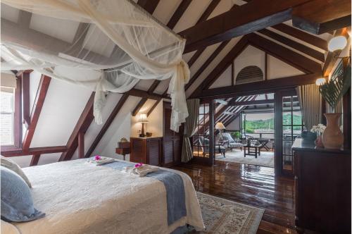 a bedroom with a large bed in a room with wooden ceilings at Admiral's Inn and Gunpowder Suites in English Harbour Town