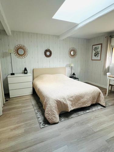 une chambre avec un lit et deux miroirs au mur dans l'établissement La grange, aux Herbiers