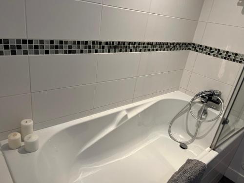 une baignoire blanche avec douche dans une salle de bain dans l'établissement La grange, aux Herbiers