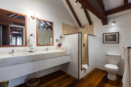 a bathroom with two sinks and a toilet at Admiral's Inn and Gunpowder Suites in English Harbour Town