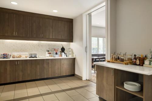 a kitchen with wooden cabinets and a counter top at Residence Inn by Marriott Jackson The District at Eastover in Jackson