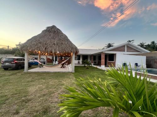 a hut with a hammock outside of a house at Villa Esmeralda del Mar in Monte Gordo