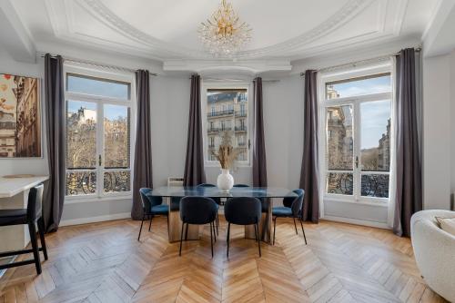 une salle à manger avec une table, des chaises et des fenêtres dans l'établissement 4 Bedroom Residence Opposite the Eiffel Tower, à Paris