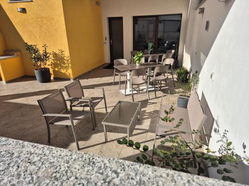 a patio with chairs and tables in a building at COMIDA Guesthouse & Experiences in Tortolì