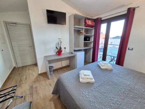 a bedroom with a bed with two towels on it at COMIDA Guesthouse & Experiences in Tortolì