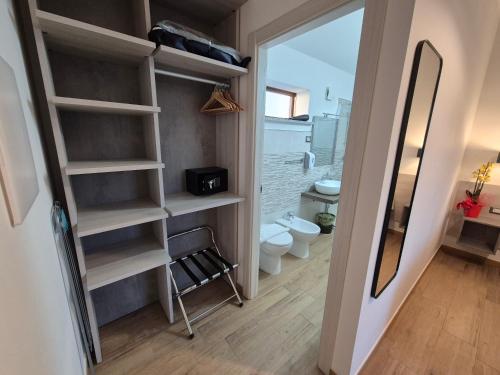 a small bathroom with a toilet and a mirror at COMIDA Guesthouse & Experiences in Tortolì
