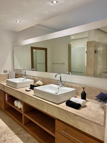 a bathroom with two sinks and a large mirror at Departamento exclusivo con playa privada - La Amada, Cancun in Cancún
