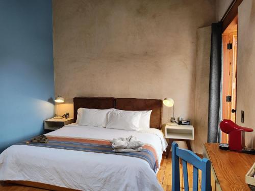 a bedroom with a bed and a red chair at Hotel Jardines del Carmen in San Cristóbal de Las Casas