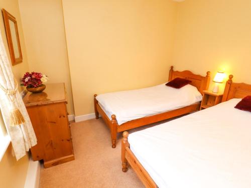 a bedroom with two beds and a table with flowers at Maiden Moor in Keswick