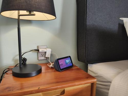 a table with a lamp and a cell phone on it at Hotel Jardines del Carmen in San Cristóbal de Las Casas