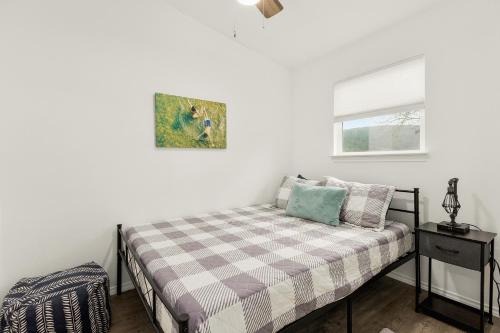 a small bedroom with a bed and a window at Hunka Hunka Cabin in New Braunfels