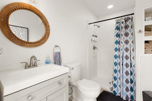 a bathroom with a sink and a toilet and a mirror at Hunka Hunka Cabin in New Braunfels