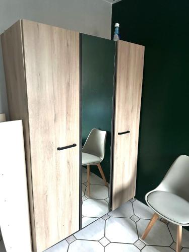 une chambre avec deux chaises et une cloison avec deux portes dans l'établissement Comfort Bedroom, à Cergy