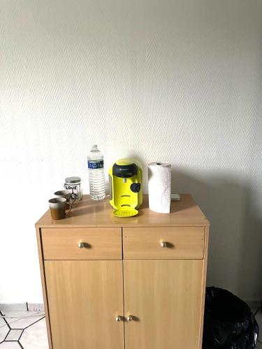 une armoire en bois avec un appareil jaune au-dessus dans l'établissement Comfort Bedroom, à Cergy
