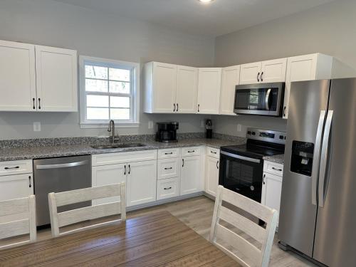 a kitchen with white cabinets and a stainless steel refrigerator at The Snowman Suite in Lexington