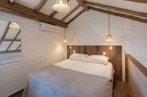 a bedroom with a bed in a room with white walls at Pousada Hanalie by Easy Hotéis in Praia do Rosa