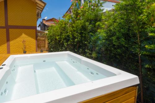 a white bath tub sitting on top of a yard at Pousada Hanalie by Easy Hotéis in Praia do Rosa