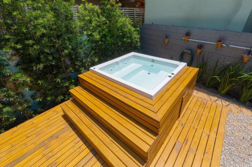 a hot tub sitting on top of a wooden deck at Pousada Hanalie by Easy Hotéis in Praia do Rosa