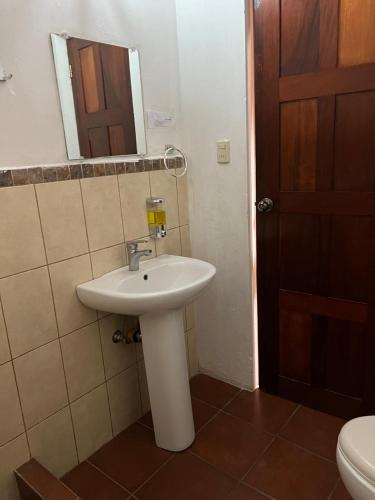a bathroom with a sink and a mirror and a toilet at NEIZAN HOTEL in Antigua Guatemala