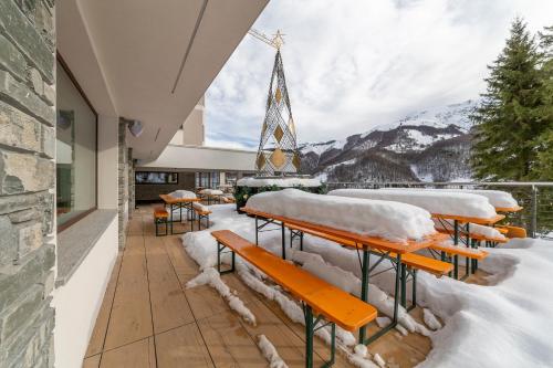 a group of benches covered in snow on a balcony at Riserva Bianca Limone Hotel & SPA in Limone Piemonte