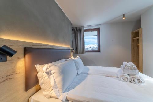 a bedroom with a bed with towels on it at Riserva Bianca Limone Hotel & SPA in Limone Piemonte
