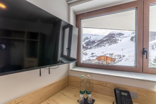 a window with a view of a snow covered mountain at Riserva Bianca Limone Hotel & SPA in Limone Piemonte